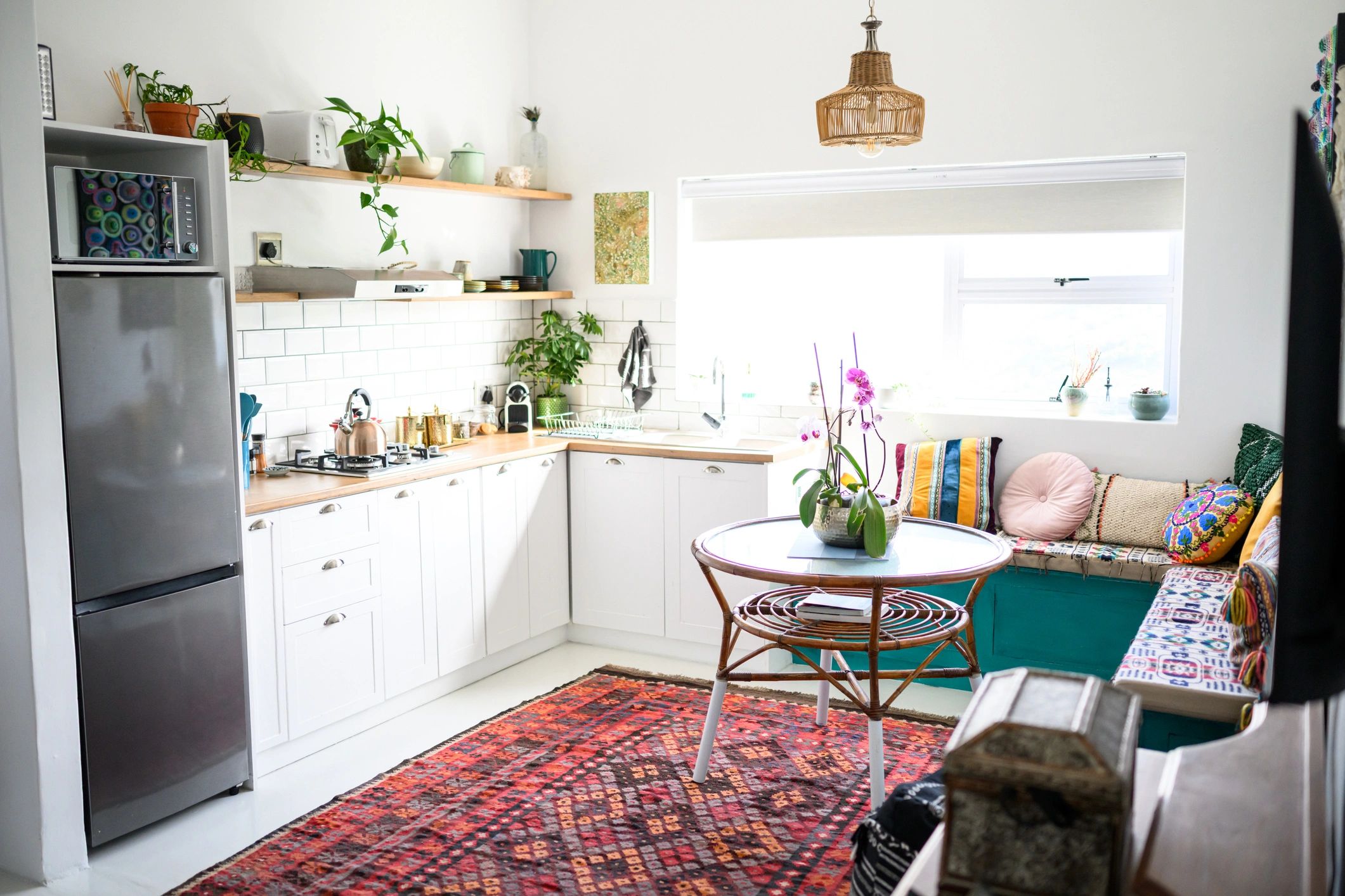 Bright modern kitchen with shelves, plants, and colorful decor