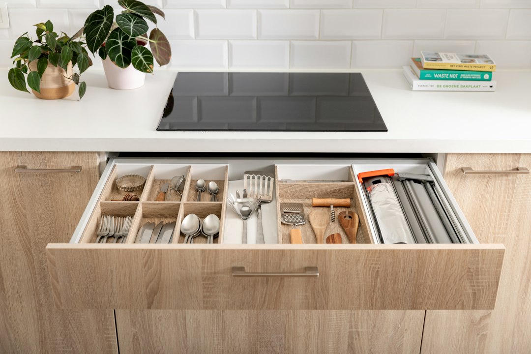 An organized wooden kitchen drawer with a cutlery insert, illustrating how compartments affect access